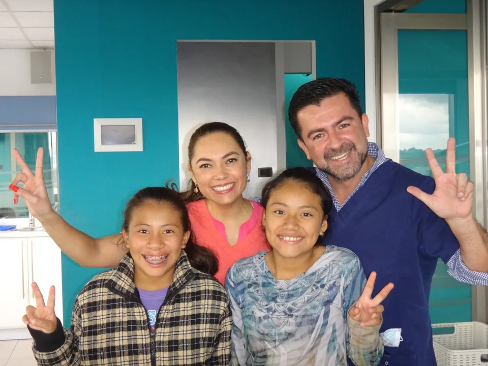 Equipo de la Fundación Sonrisa 502 con dos niñas sonriendo en la clínica